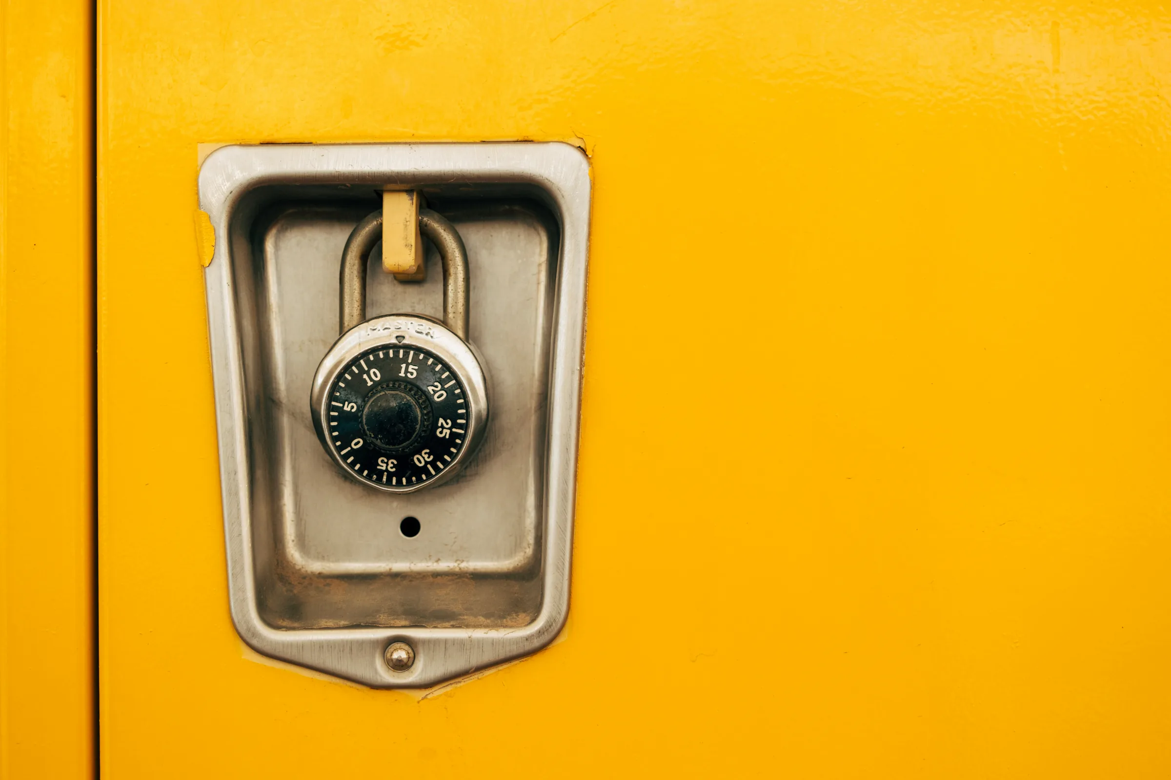 A combination lock on a yellow locker